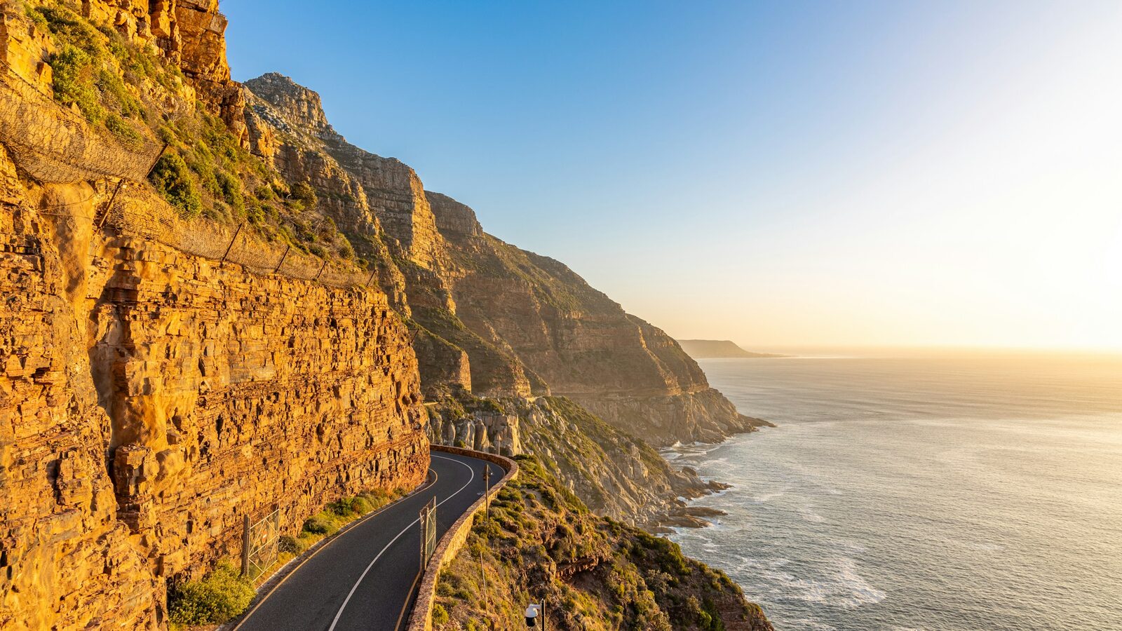Chapman's Peak Drive curving along the cliffs above the Atlantic at sunset.